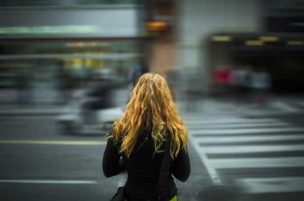 Woman Standing looking at traffic in front of her