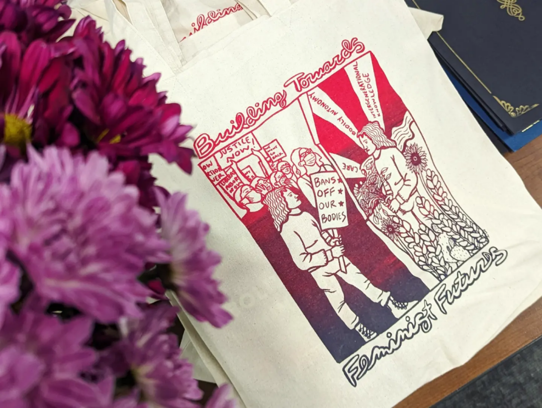Building Towards Feminist Futures tote bag. Image created by GWS alum Monica Trinidad. Screenprinting completed by Hoofprint Workshop.