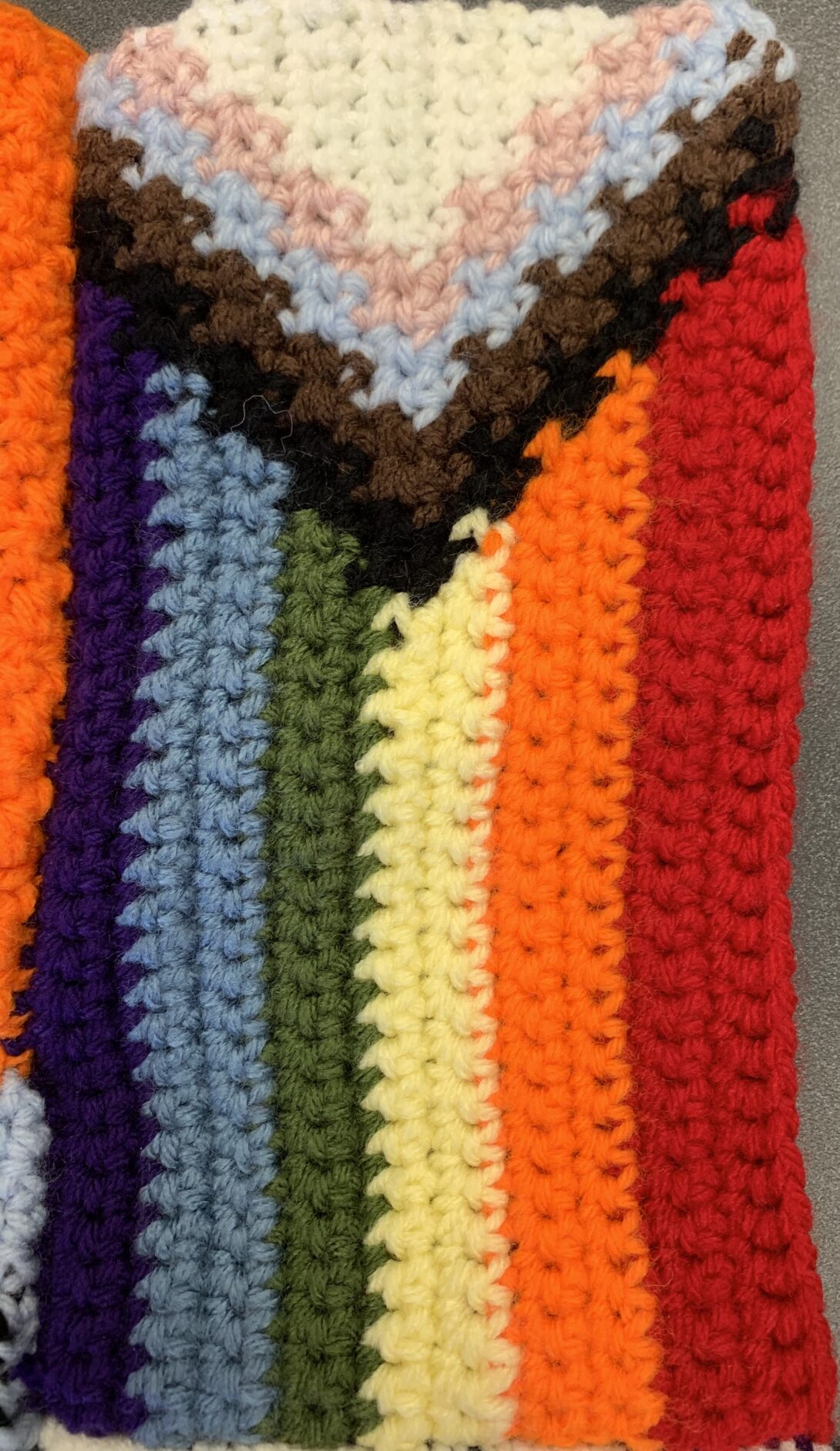 A crocheted progress pride flag