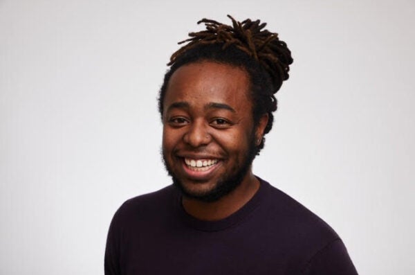 headshot of Dr. Ash Stephens looking at the camera, smiling, wearing a black shirt